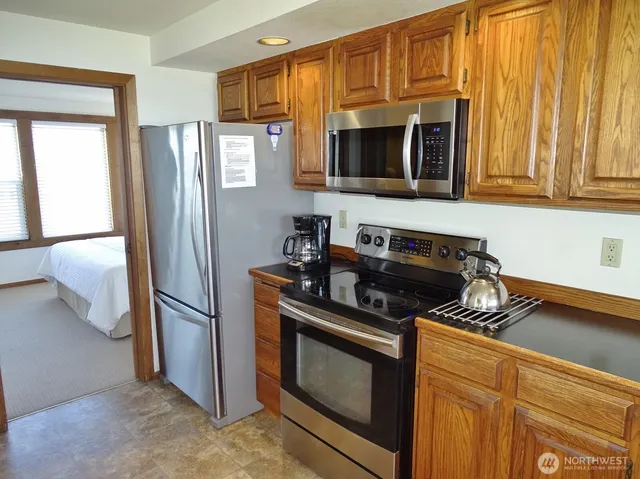 a kitchen with stainless steel appliances granite countertop a refrigerator and a stove top oven