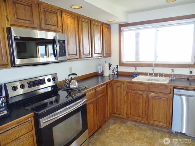 a kitchen with stainless steel appliances granite countertop a sink stove and cabinets