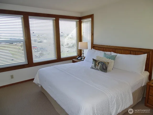 a large bed sitting in a bedroom next to a window