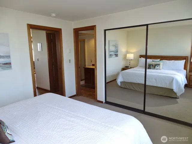 a bedroom with a bed and two mirror