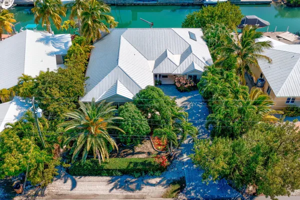 an aerial view of a house with yard and lake view