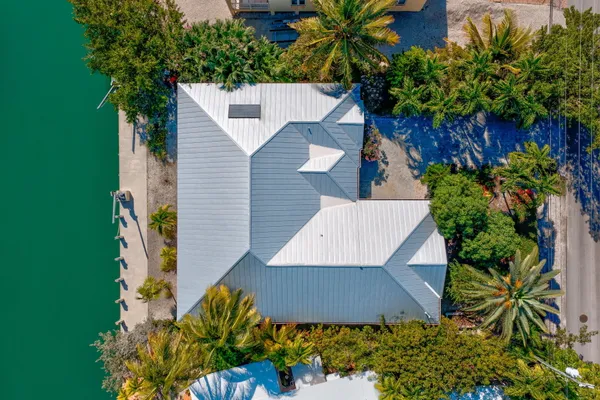 an aerial view of residential houses with outdoor space and trees