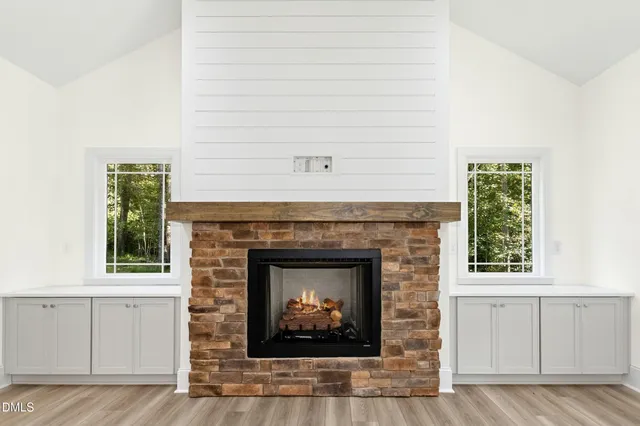 a view of an empty room with a fireplace and a window