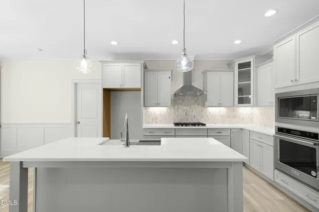 a kitchen with kitchen island a sink stainless steel appliances and cabinets