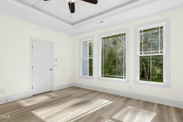 a view of a room with wooden floor and a ceiling fan