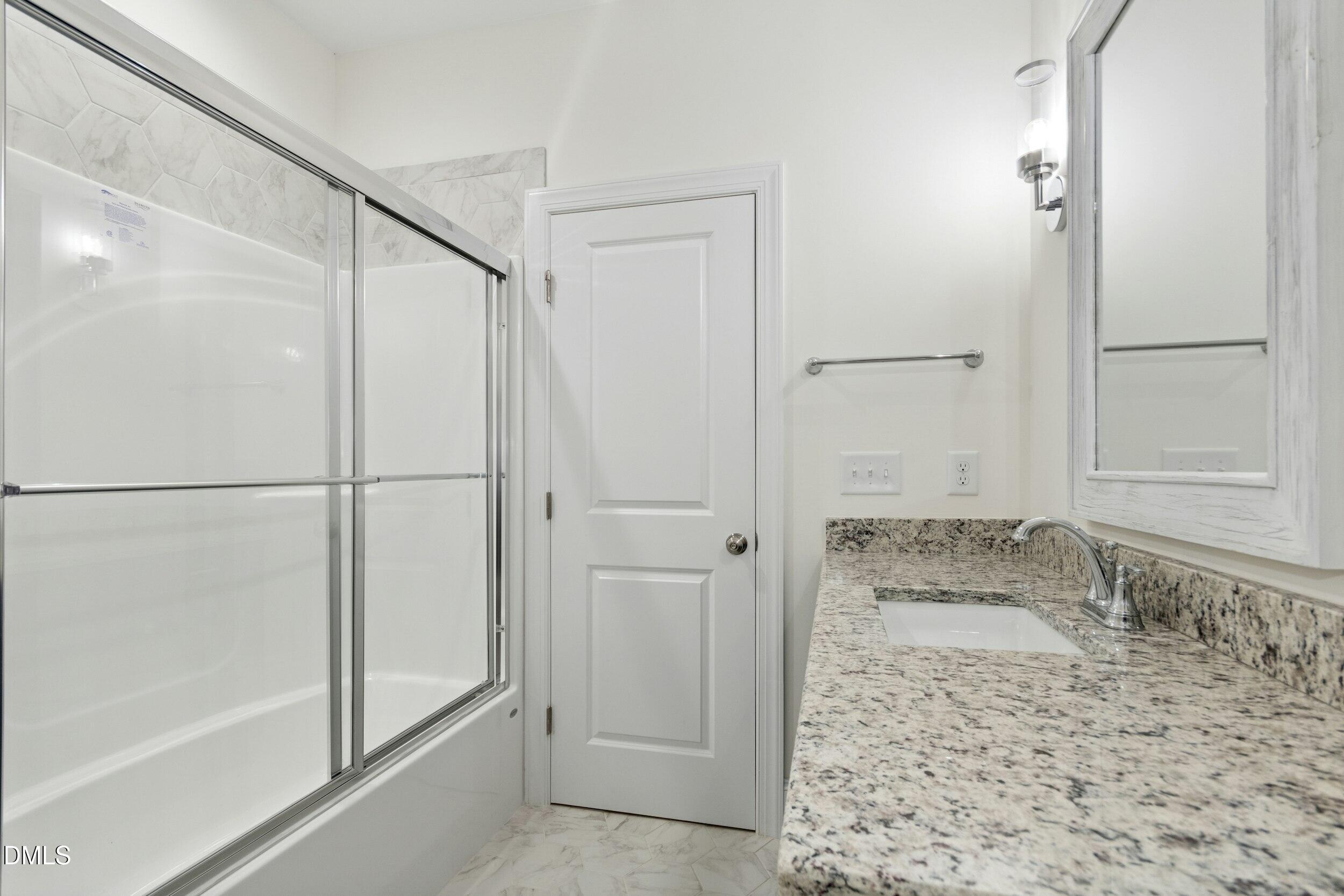 925 Lynch Road Selma, NC 27576 - Photo 26 of 39 a bathroom with a granite countertop window and a shower