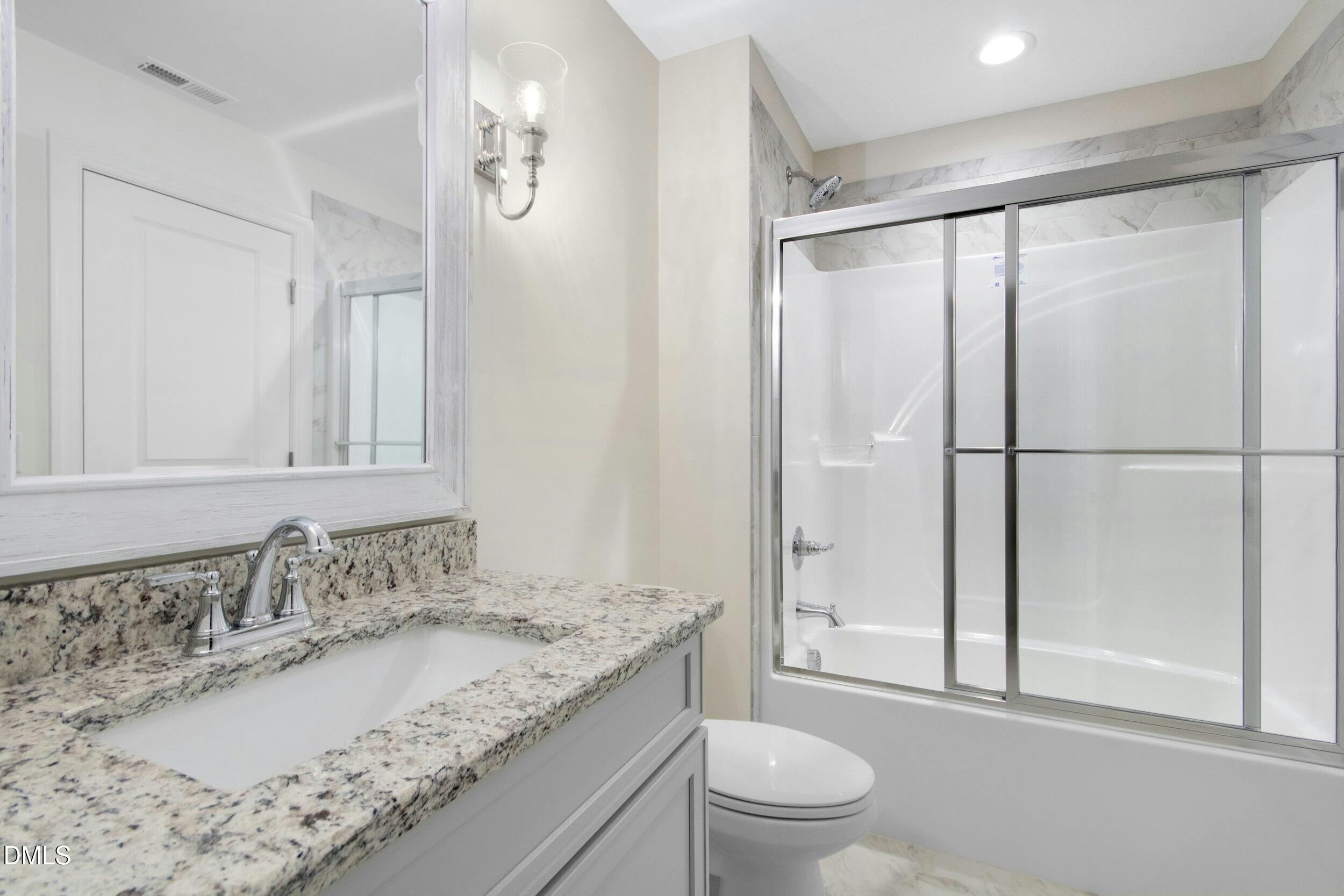 925 Lynch Road Selma, NC 27576 - Photo 29 of 39 a bathroom with a granite countertop sink toilet and shower