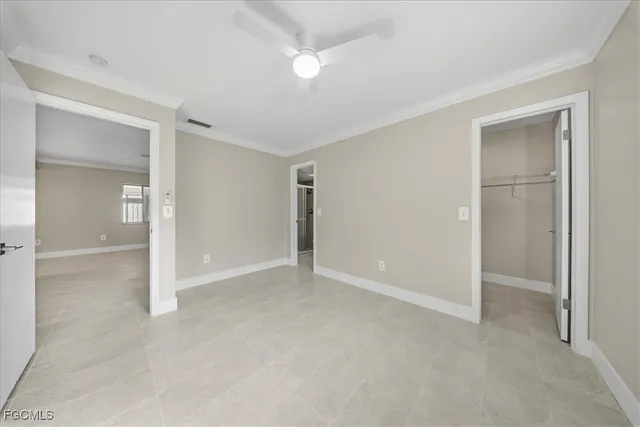 an empty room with closet and a ceiling fan