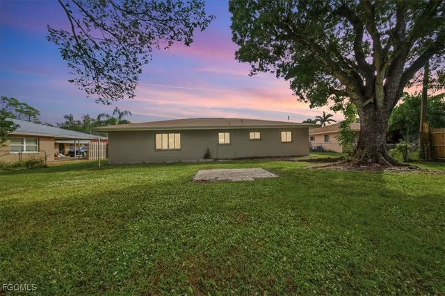 a view of a house with a big yard and a large tree