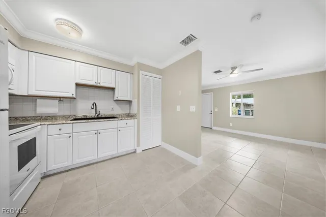 a white refrigerator freezer and a stove sitting inside of a kitchen