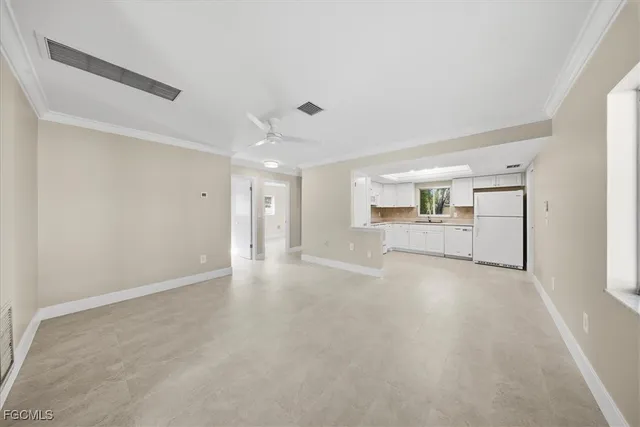 a view of a livingroom with wooden floor kitchen and a sink