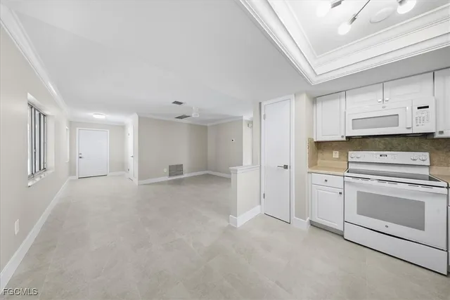 a kitchen with white cabinets and white appliances