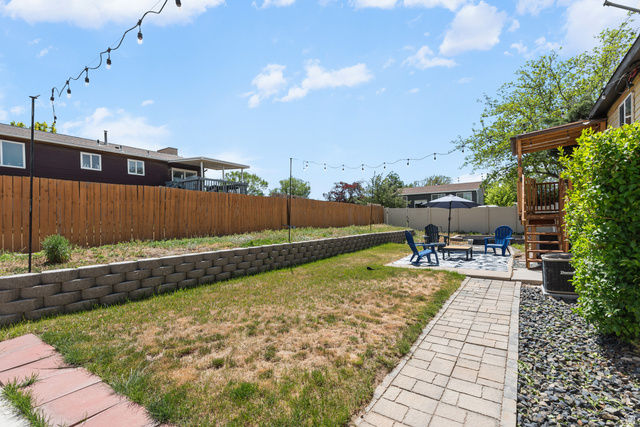 3951 Brixton Road Salt Lake City, UT 84129 - Photo 21 of 22 Spacious backyard featuring a paver patio area, built-in retaining wall, and a wood privacy fence