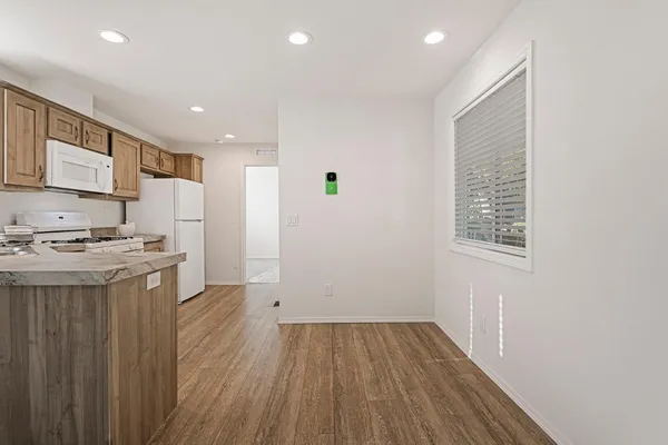 a view of kitchen with a sink wooden cabinets and entryway