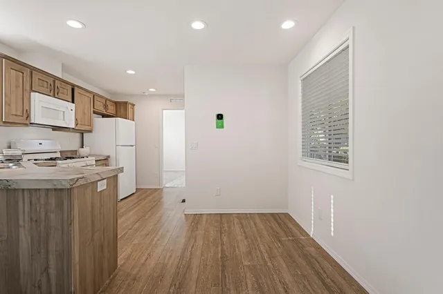a view of kitchen with a sink wooden cabinets and entryway