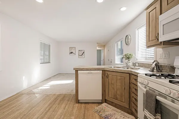 a kitchen with granite countertop a sink cabinets and stainless steel appliances