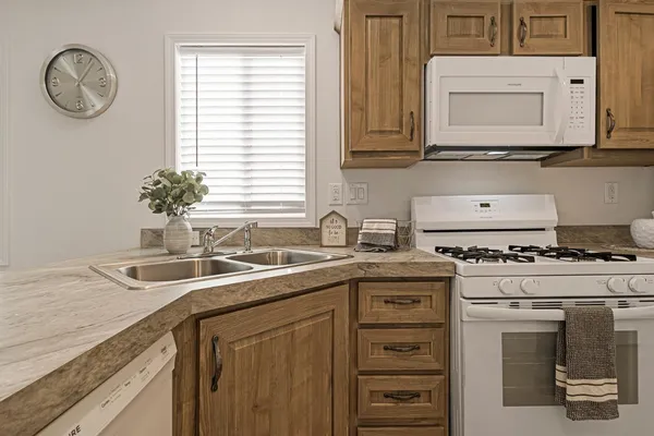 a kitchen with stainless steel appliances granite countertop a sink a stove and a window