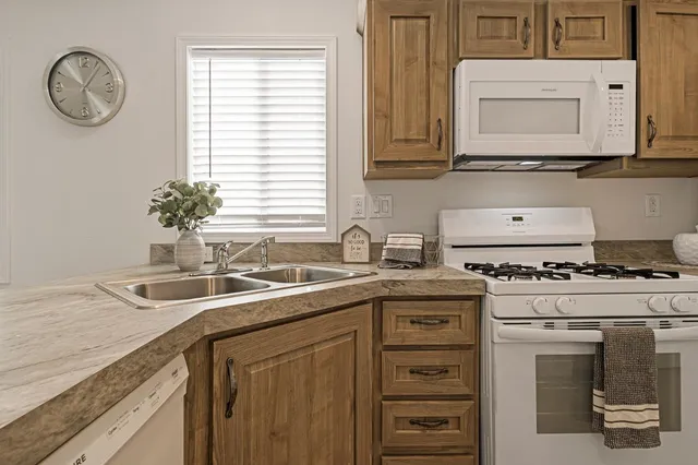 a kitchen with stainless steel appliances granite countertop a sink a stove and a window