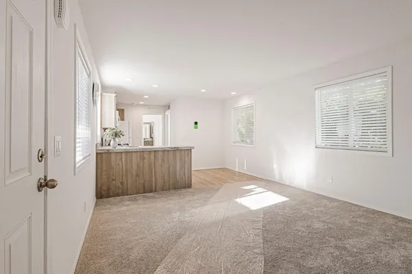 a view of a hallway with a dinning room and windows