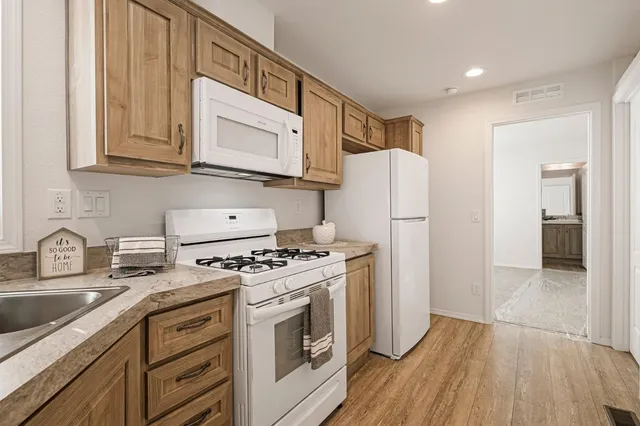 a kitchen with stainless steel appliances granite countertop a refrigerator stove and sink