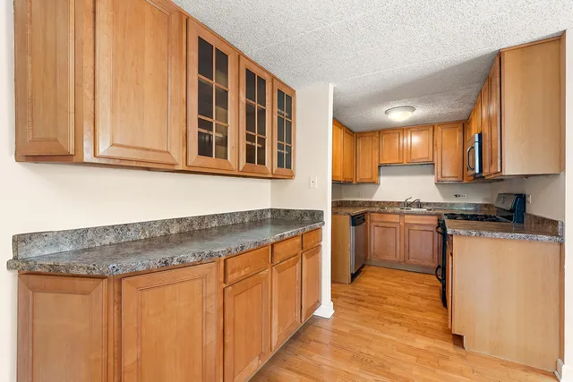 a kitchen with stainless steel appliances granite countertop wooden cabinets a sink and a stove