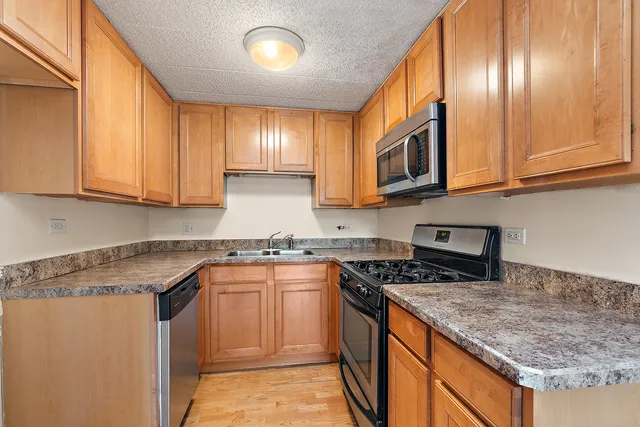 a kitchen with stainless steel appliances granite countertop a sink stove and cabinets