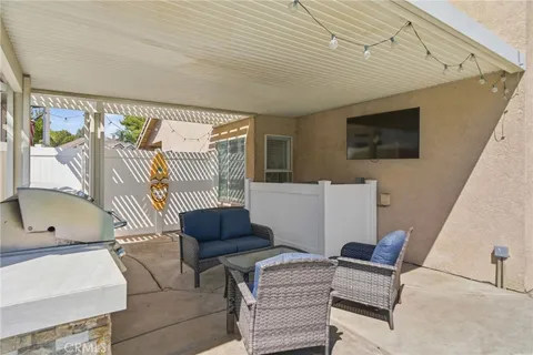 a view of a patio with table and chairs potted plants with floor to ceiling window