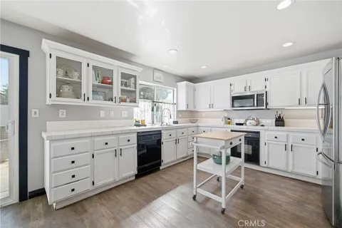 a kitchen with a refrigerator and a stove top oven