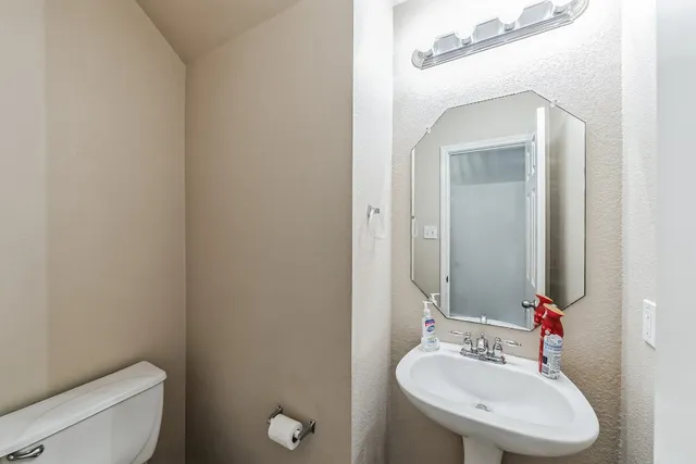 a bathroom with a sink a toilet and mirror
