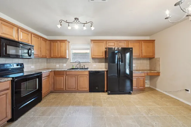 a kitchen with stainless steel appliances granite countertop a refrigerator stove top oven a sink and dishwasher