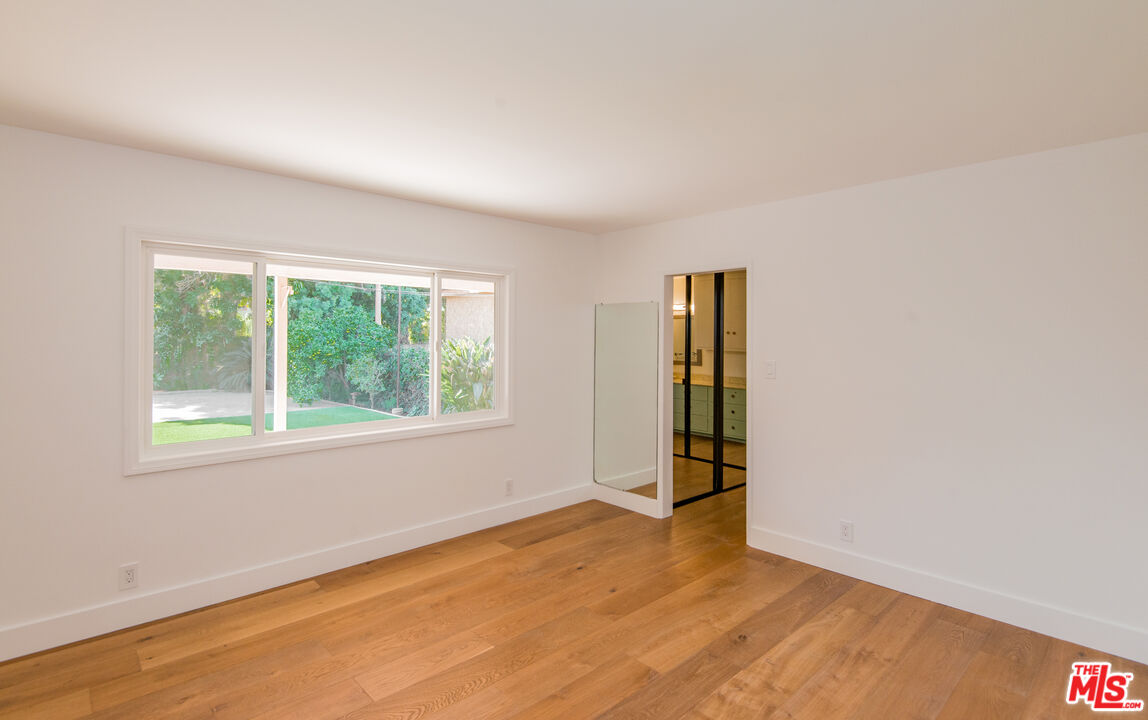 13104 West Magnolia Boulevard Sherman Oaks, CA 91423 - Photo 16 of 27 an empty room with wooden floor and windows
