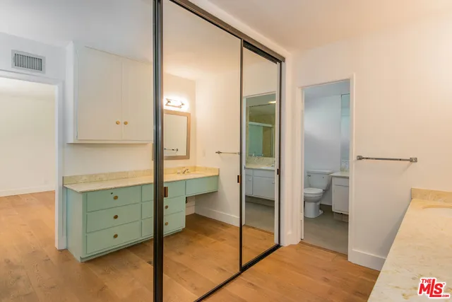 a bathroom with a glass door shower a sink and a toilet