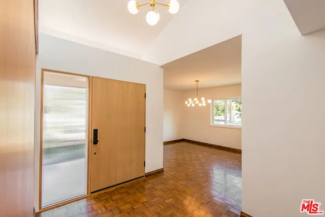 a view of empty room with window and wooden floor