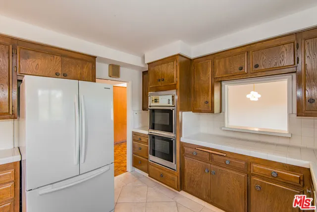a kitchen with stainless steel appliances granite countertop a refrigerator and a stove top oven
