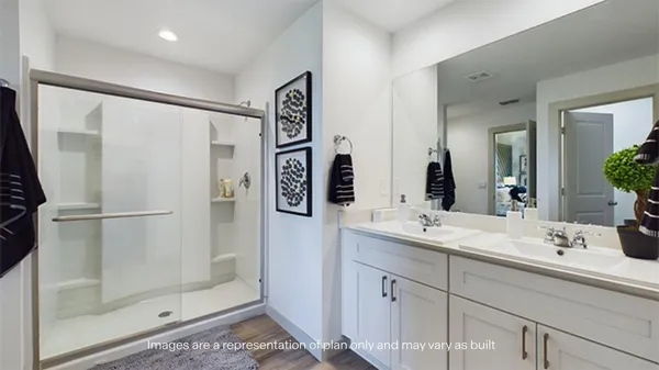 a bathroom with a double vanity sink mirror and shower