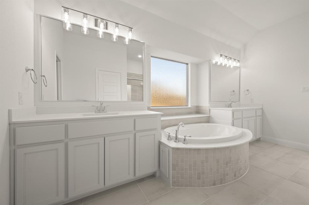 701 Seahawk Street Joshua, TX 76058 - Photo 13 of 30 a bathroom with a bathtub a double vanity sink and mirror