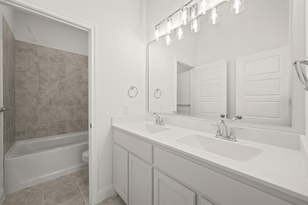 701 Seahawk Street Joshua, TX 76058 - Photo 18 of 30 a bathroom with a bathtub a sink and a large mirror