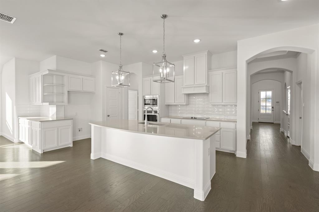 701 Seahawk Street Joshua, TX 76058 - Photo 3 of 30 a large kitchen with kitchen island a white counter space a sink and appliances