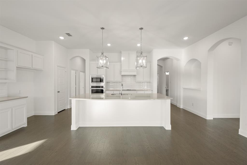 701 Seahawk Street Joshua, TX 76058 - Photo 4 of 30 a large white kitchen with a large island oven a refrigerator and a sink