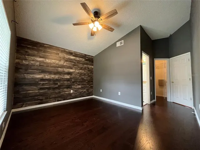 a view of an empty room with a chandelier fan