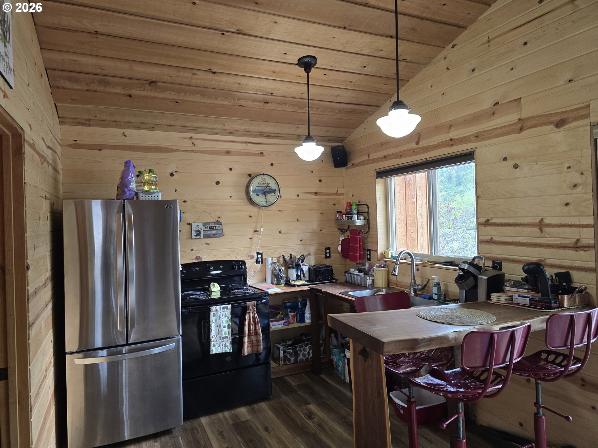 84665 Grande Ronde Road Enterprise, OR 97828 - Photo 5 of 27 a kitchen with stainless steel appliances granite countertop a refrigerator a sink dishwasher a dining table and chairs with wooden floor