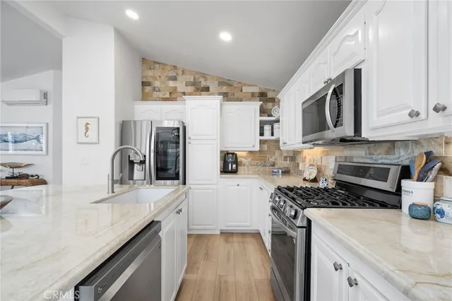 a kitchen with granite countertop a stove sink and refrigerator