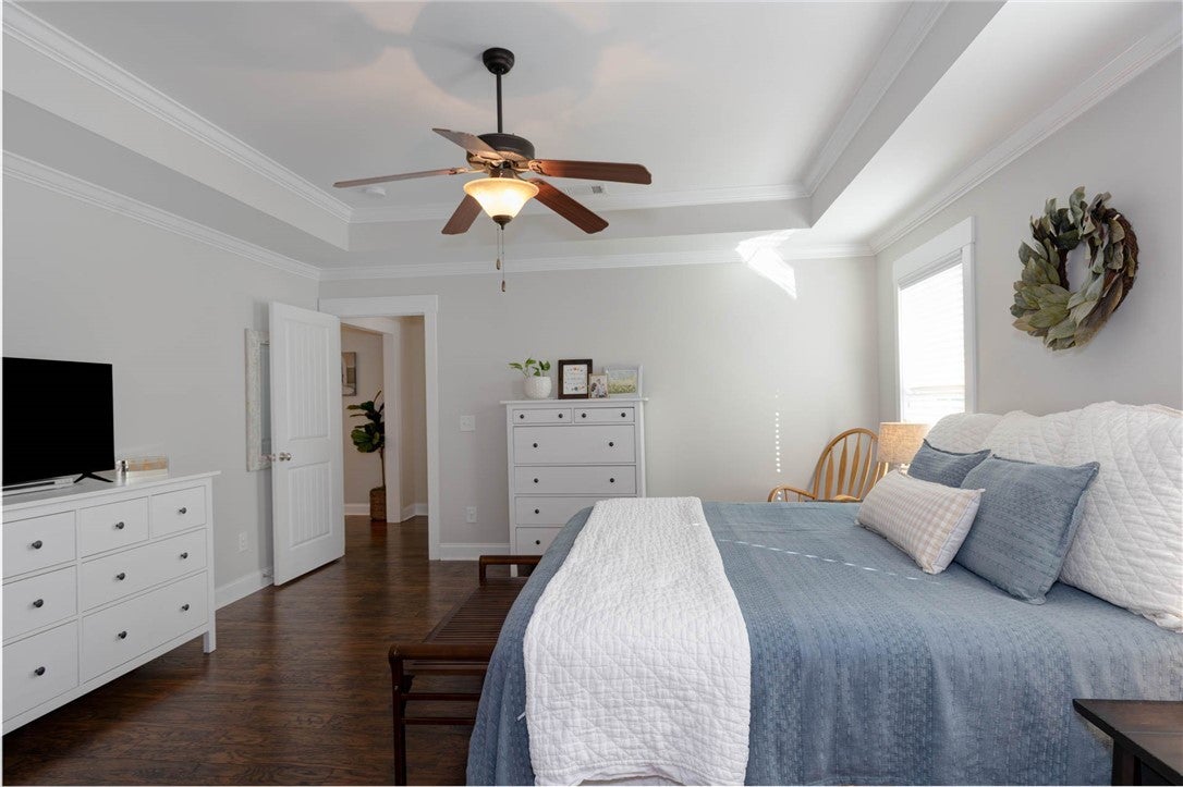 641 Deer Run Road Auburn, AL 36832 - Photo 21 of 28 This tranquil bedroom features crown molding, a ceiling fan, and rich hardwood flooring, perfect for serene living.