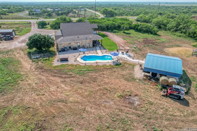 an aerial view of a house with a garden and lake view
