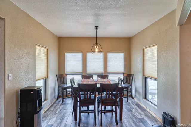 a view of a a dining room with furniture window and wooden floor
