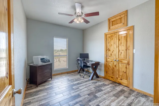 a view of a workspace with furniture and a window