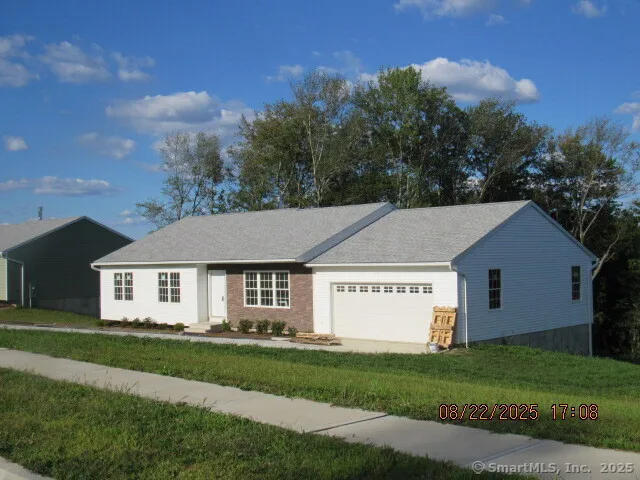 a view of a white house with a big yard and large trees