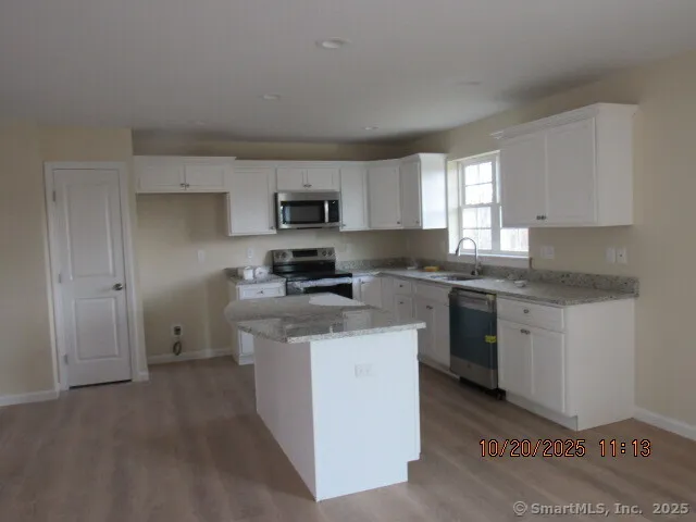 a kitchen with stainless steel appliances a sink stove refrigerator and window