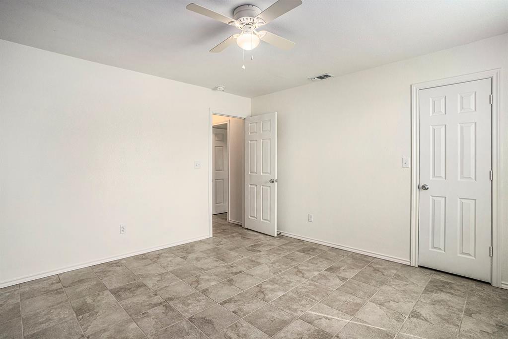 405 North Cleburne Whitney Road Rio Vista, TX 76093 - Photo 13 of 23 White walls, ceiling fan with integrated lighting, tile flooring, and multiple six-panel doors