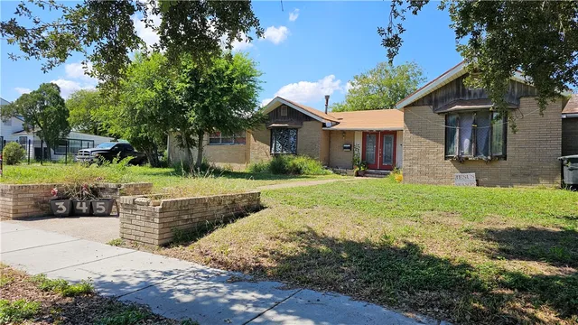 a front view of a house with a yard and potted plants